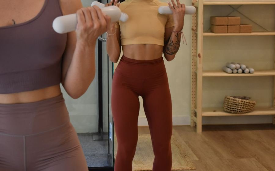 Dos alumnas de SHE Barre trabajando la fuerza con pesas en el estudio